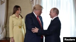 TT Nga Vladimir Putin, phải, chào mừng TT Trump của Mỹ, tại cuộc gặp gỡ ở Helsinski, Phần Lan, ngày 16/7/2018. DNPN Melania đứng phía sau. Sputnik/Alexei Nikolsky/Kremlin via REUTERS 