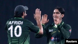 Pakistan's Shahid Afridi (L) congratulates Mohammad Hafeez as he dismissed Bangladesh's Shahriar Nafees successfully during their second One Day International, ODI cricket match of the series in Dhaka December 3, 2011. REUTERS/Andrew Biraj (BANGLADESH - T