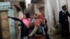 In this Jan. 30, 2013 photo, a Pakistani police officer, right, guards a group of health workers going from house to house to give polio vaccines to children in Islamabad, Pakistan.