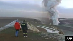 In this image from television, people watch a plume rising from the Grimsvotn volcano in Iceland, May 25 2011