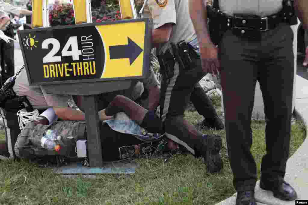 Police officers detain a demonstrator during the protest of Michael Brown&#39;s shooting death in Ferguson, Missouri, Aug. 18, 2014.