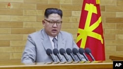 Lãnh tụ Triều Tiên Kim Jong Un đọc diễn văn đầu năm tại một địa điểm không được tiết lộ, trong một bức hình trích từ một video được công bố bởi KRT vào ngày 1 tháng 1, 2018.