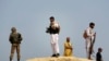 Local residents keeping security join forces with soldiers as they guard the site of a bomb blast in Adezai on the outskirts of Peshawar, located in Pakistan's restive North West Frontier Province, February 23, 2010. The remote-controlled bomb attack appa